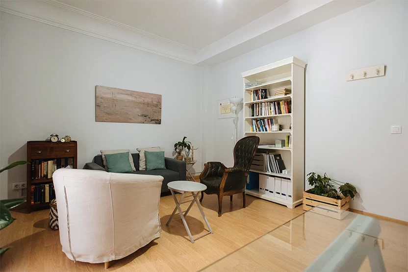 Consulta de psicoterapia con sillones y librería