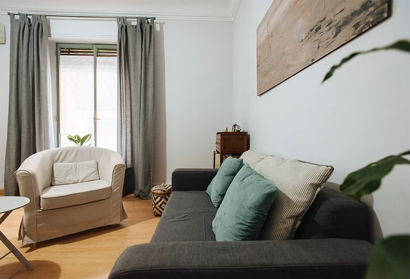 Espacio de terapia con sofá y sillón junto a la ventana